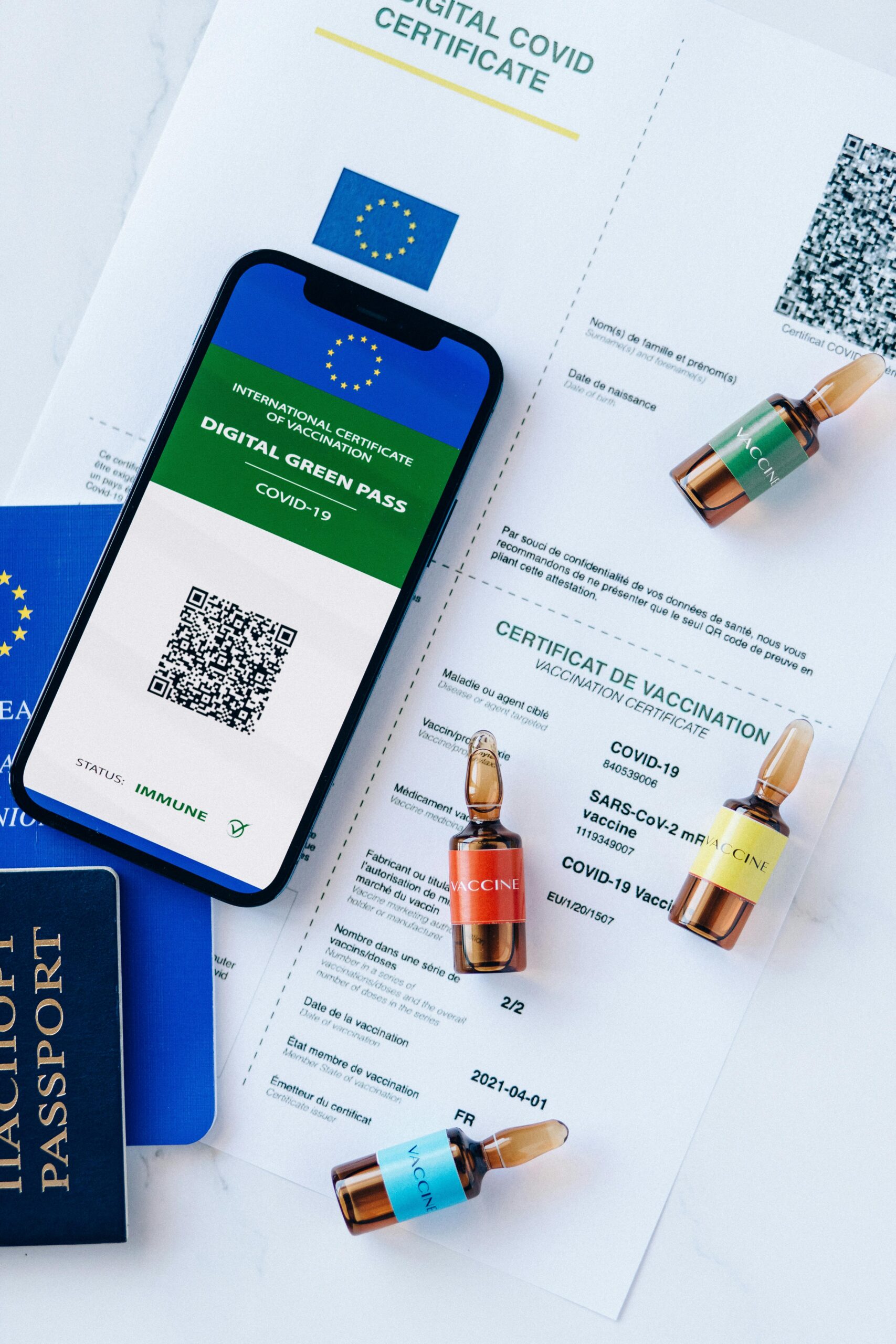 Digital COVID-19 vaccination passport with vials on a desk, symbolizing travel safety.